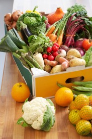 Cardboard box of assorted vegetables on kitchen counter